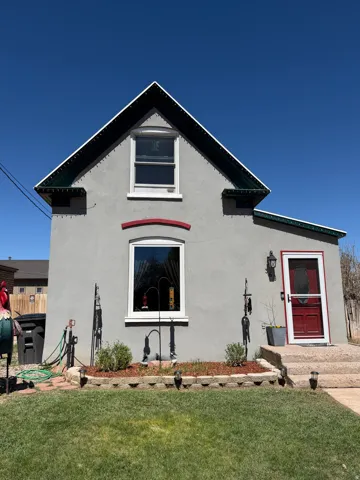 View of front of home featuring stucco siding and a front yard