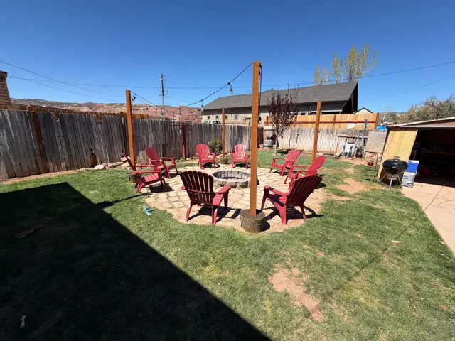 Fenced backyard featuring an outdoor fire pit and a patio area