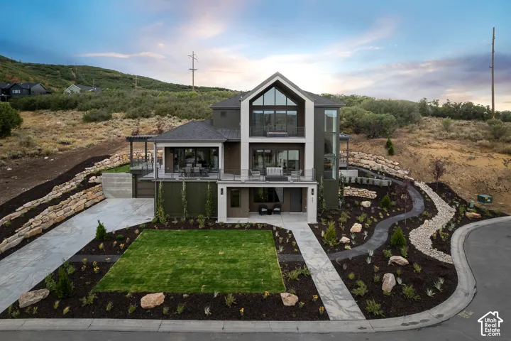 View of front of home with a patio area, a balcony, and concrete driveway