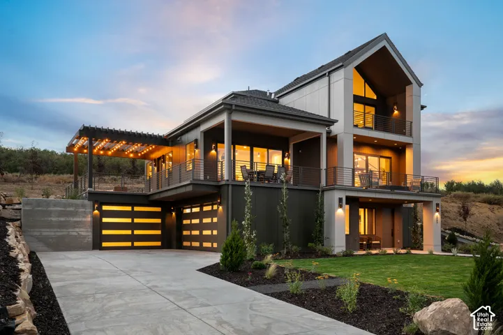 View of front of property featuring a front lawn, a garage, driveway, and board and batten siding