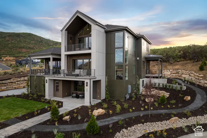 Back of property at dusk with a balcony
