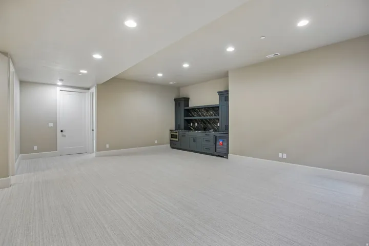 Spacious room featuring light-toned carpeting and recessed ceiling lighting