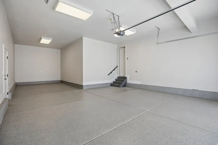 Spacious garage featuring a finished epoxy floor, recessed lighting, and direct interior access