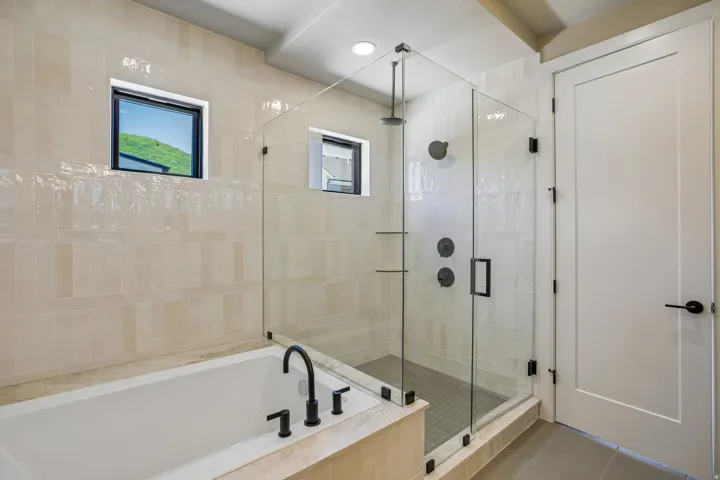 Contemporary bathroom featuring a freestanding soaking tub with matte black fixtures