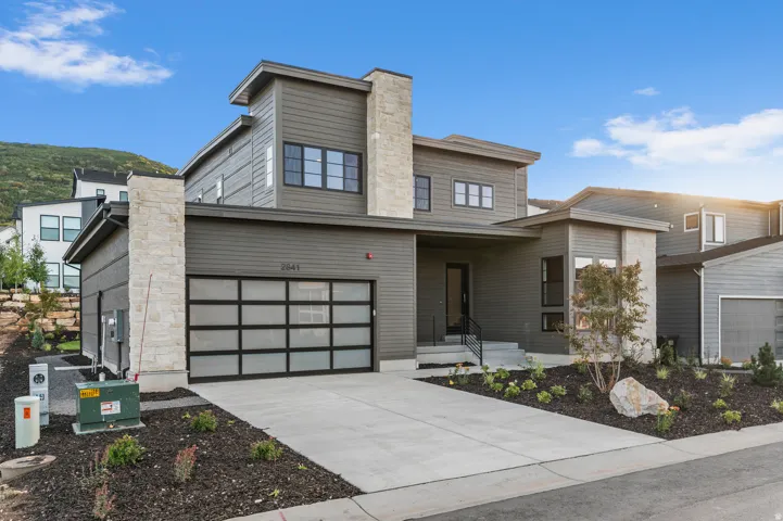 Modern architectural exterior with a stone and horizontal siding facade