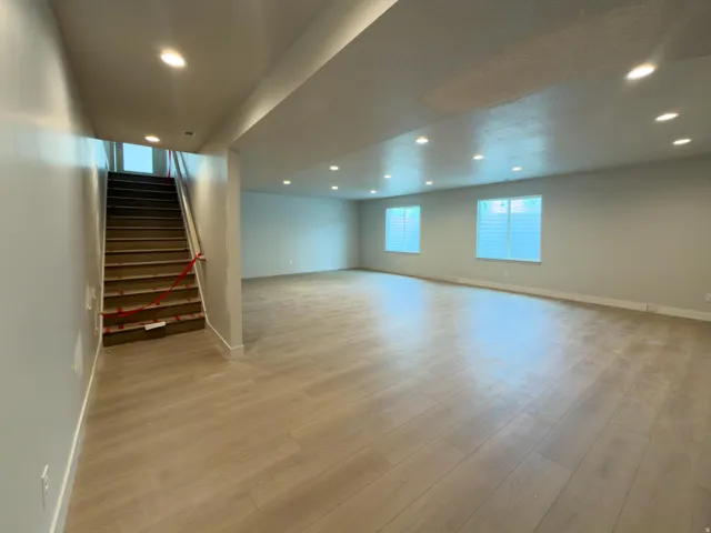 Expansive open-concept room featuring wood-finish flooring, recessed lighting, and multiple windows