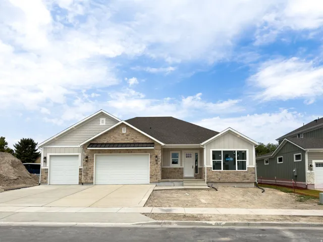 Exterior featuring a stone and siding facade, covered entry, and attached two-car garage