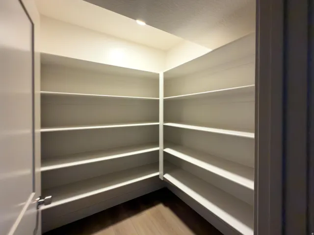 Built-in corner shelving with recessed lighting and wood-finish flooring