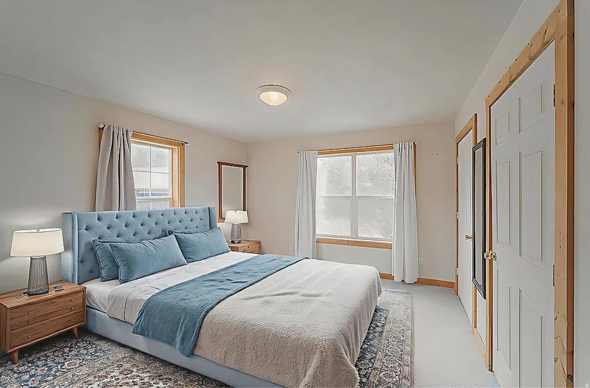 Bedroom featuring light colored carpet and multiple closets