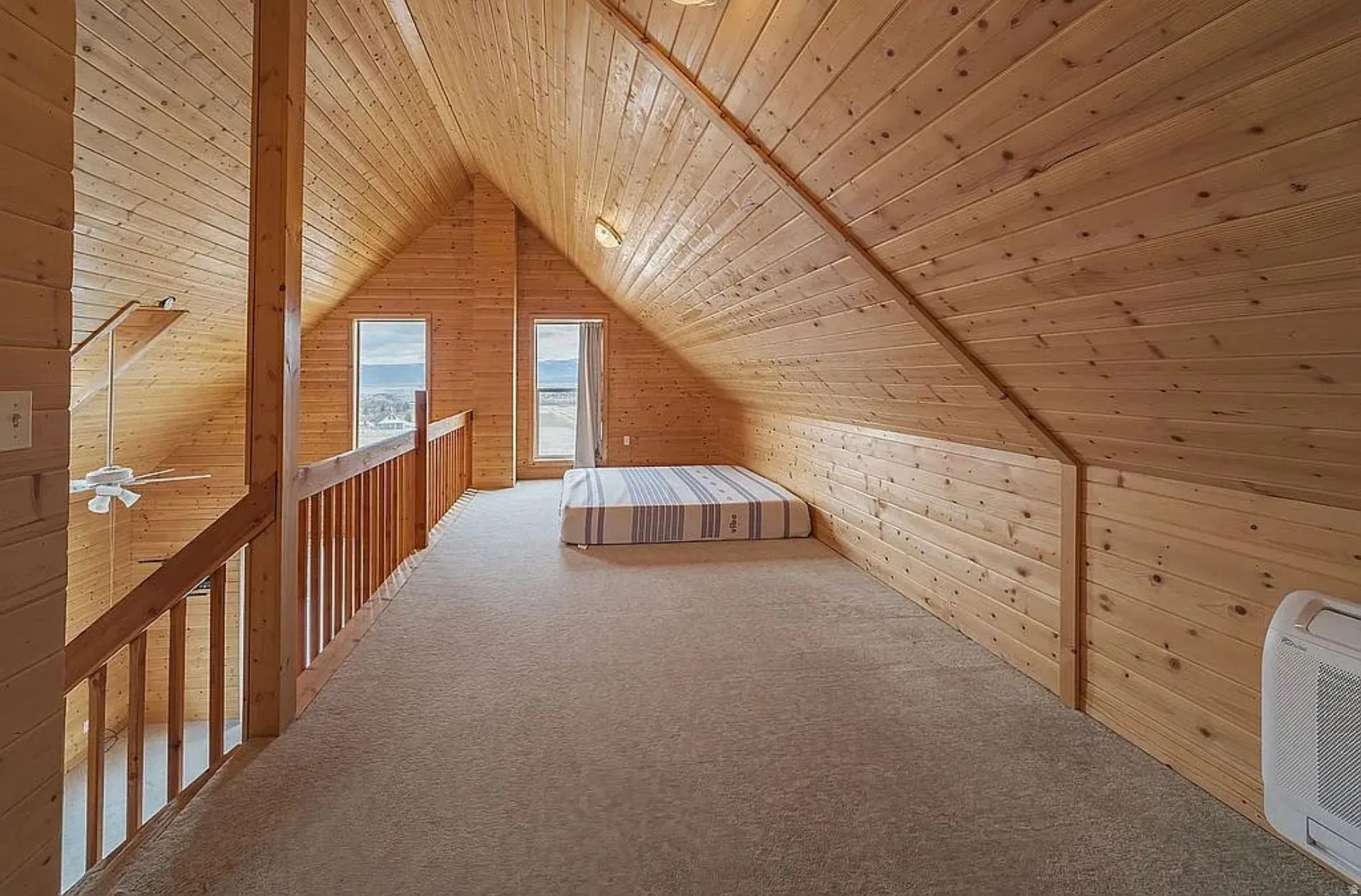 Unfurnished bedroom with wood walls, wooden ceiling, carpet flooring, and heating unit