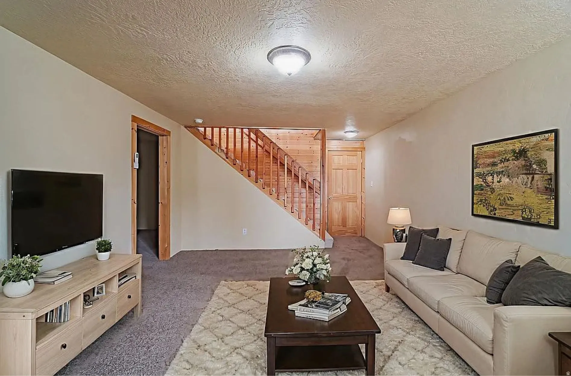 Living room with light carpet and a textured ceiling