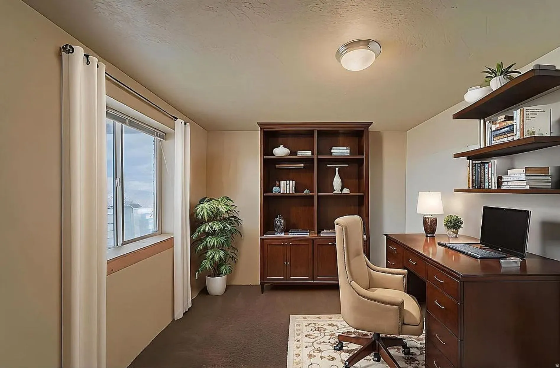 Home office with dark carpet and a textured ceiling