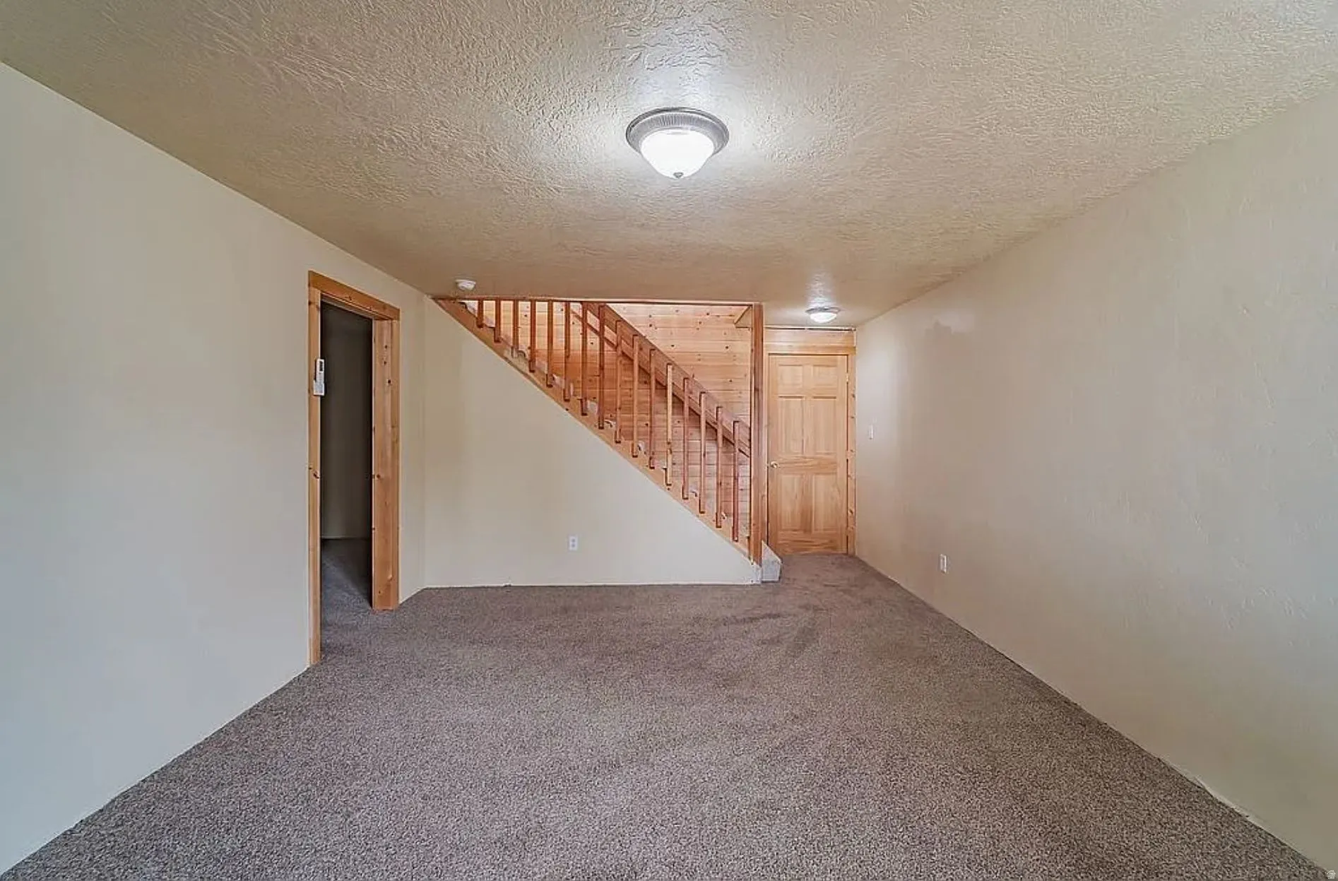 Finished below grade area with carpet and a textured ceiling