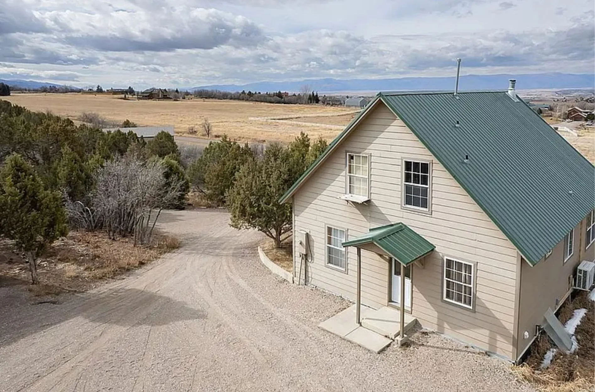 View of front facade with a metal roof, driveway, and a view of countryside