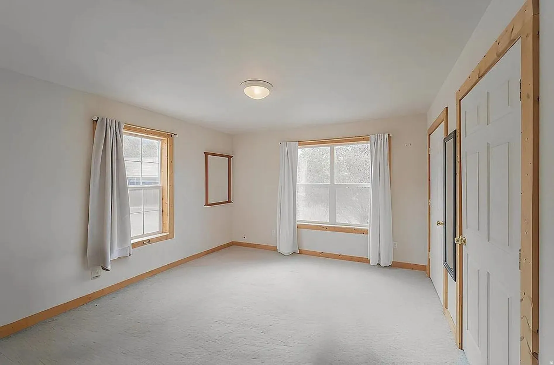 Spare room featuring baseboards and light colored carpet
