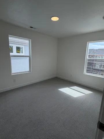 Carpeted empty room featuring baseboards and a textured ceiling