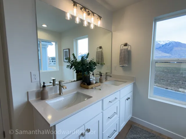 Full bath featuring double vanity and baseboards