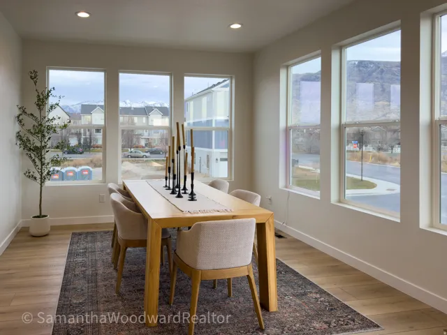 Dining room with light wood finished floors and recessed lighting