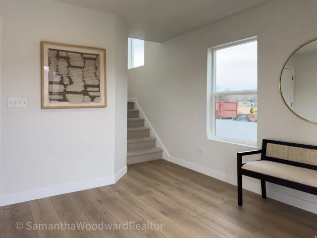 Unfurnished room featuring stairs and light wood-style flooring