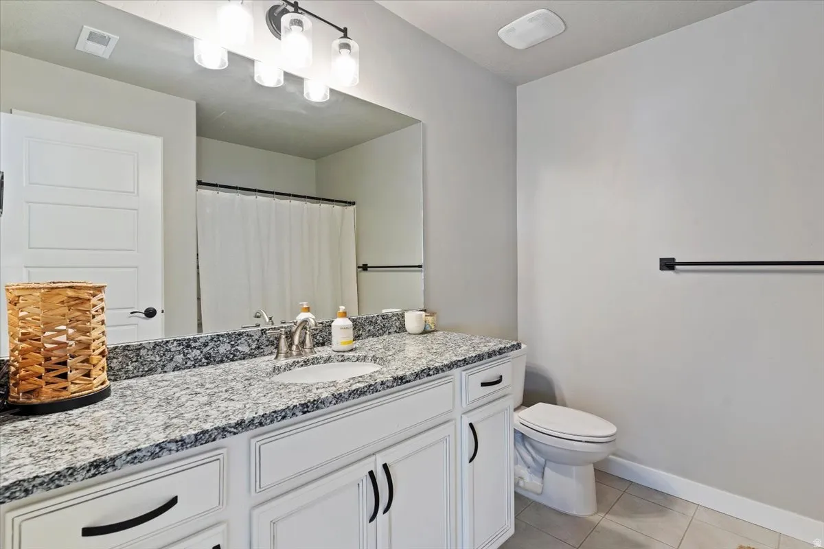 Bathroom with vanity, a shower with shower curtain, and light tile patterned flooring