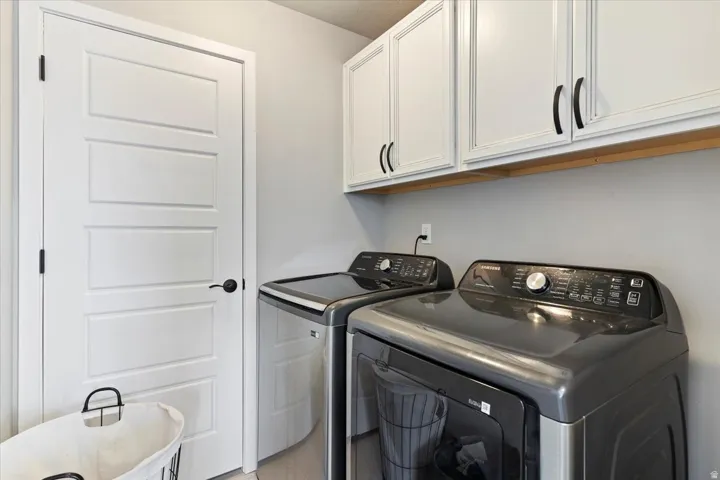 Laundry area featuring cabinet space and washing machine and clothes dryer