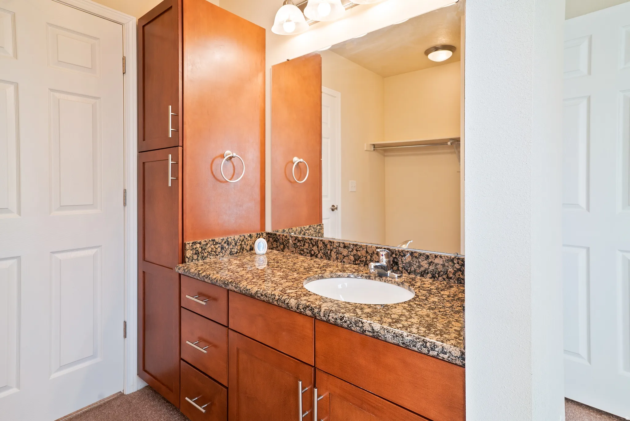 Bathroom featuring vanity and privacy door to hall bath