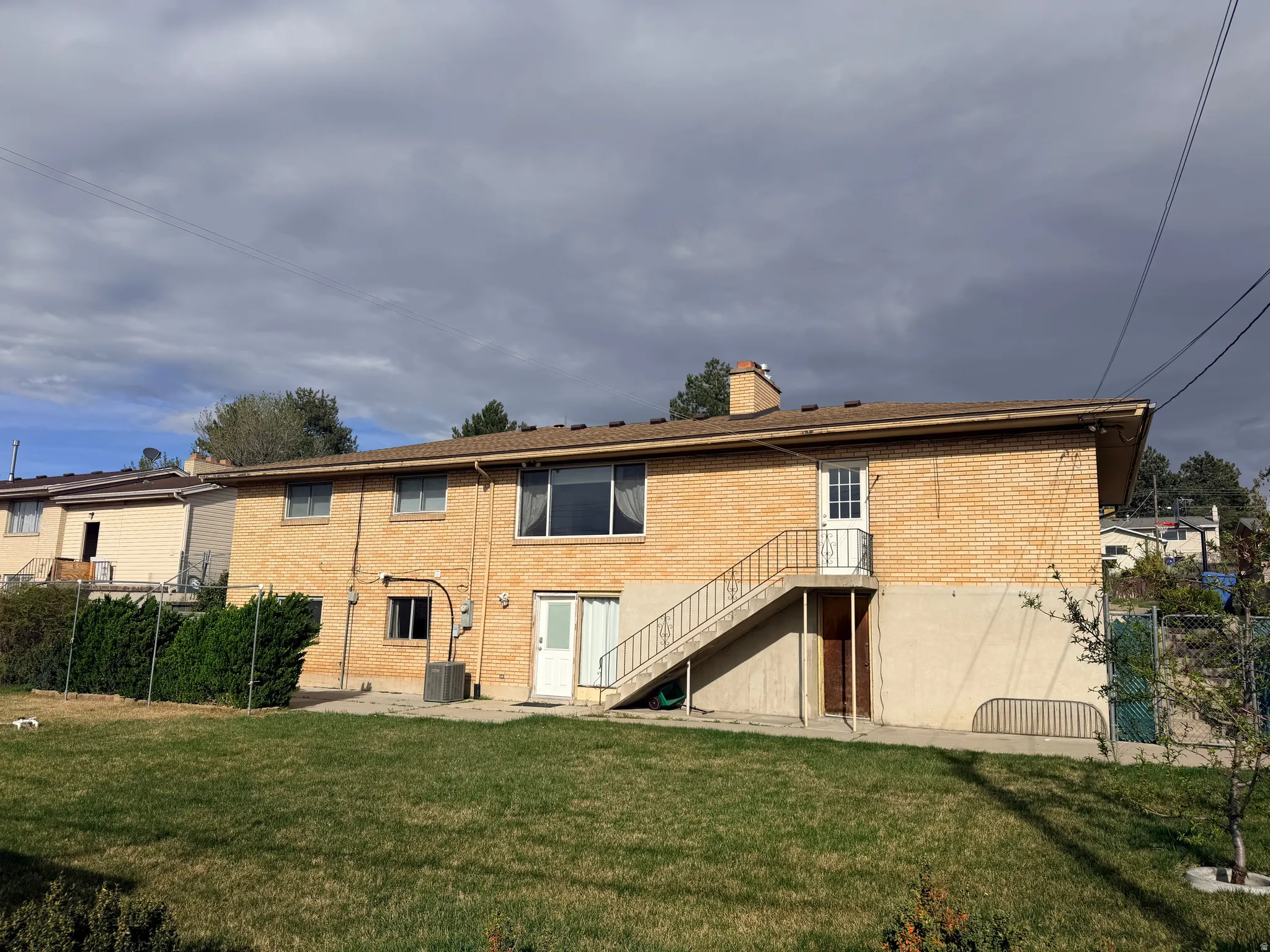 Back of property with brick siding, a chimney, and a patio area