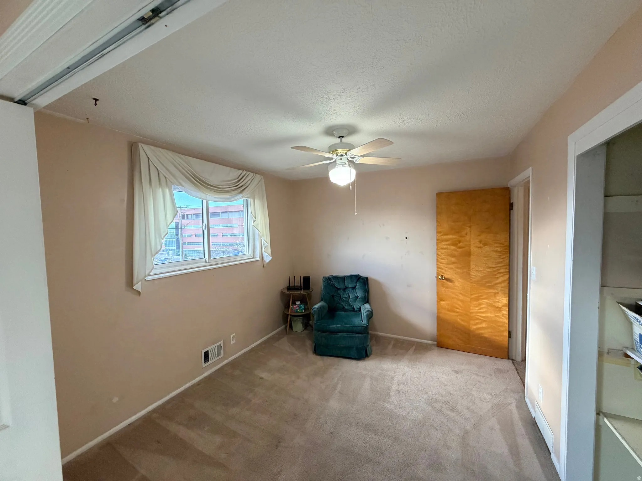 Unfurnished room with carpet floors, ceiling fan, and a textured ceiling