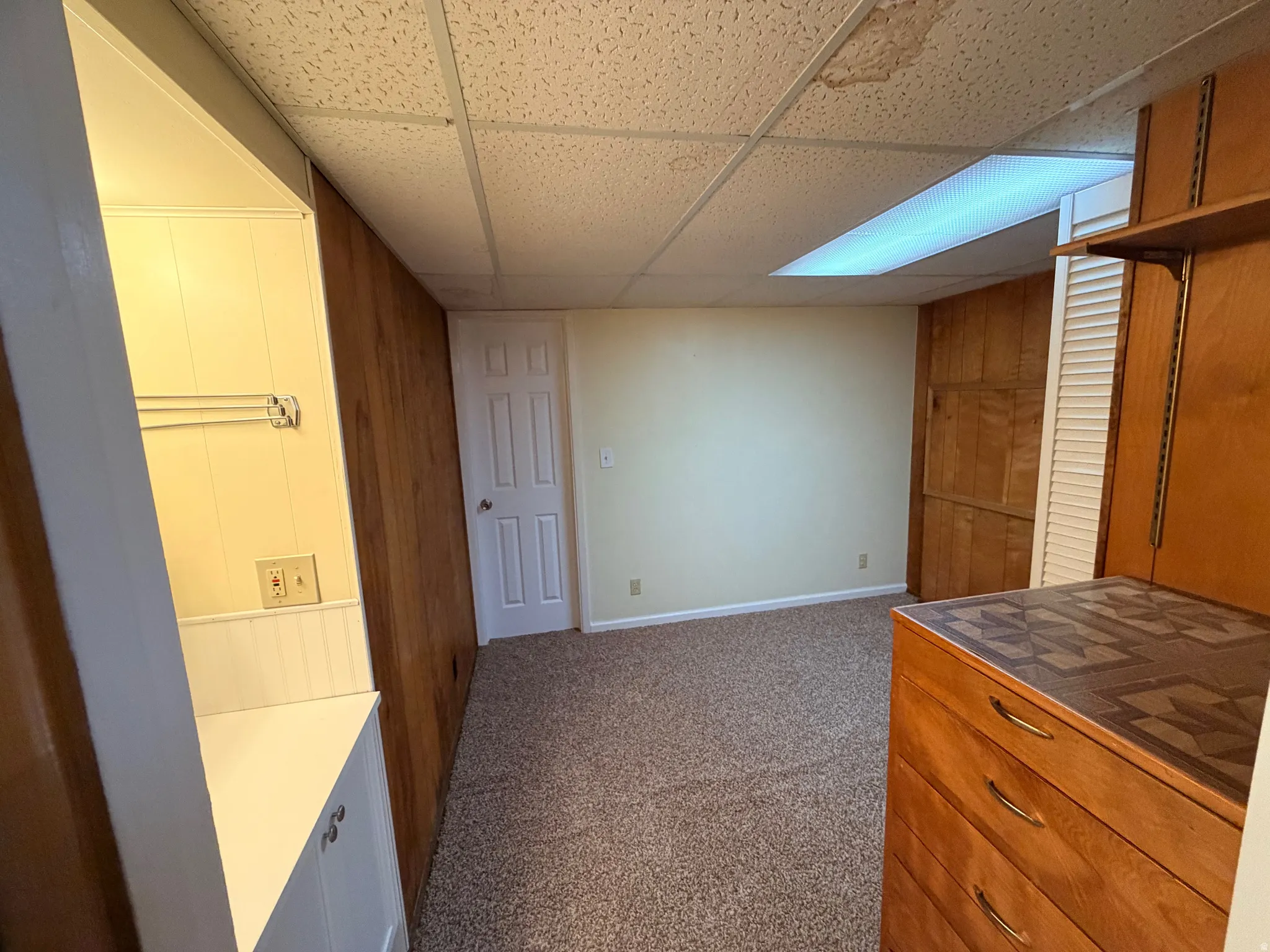 Kitchen featuring a paneled ceiling and dark carpet