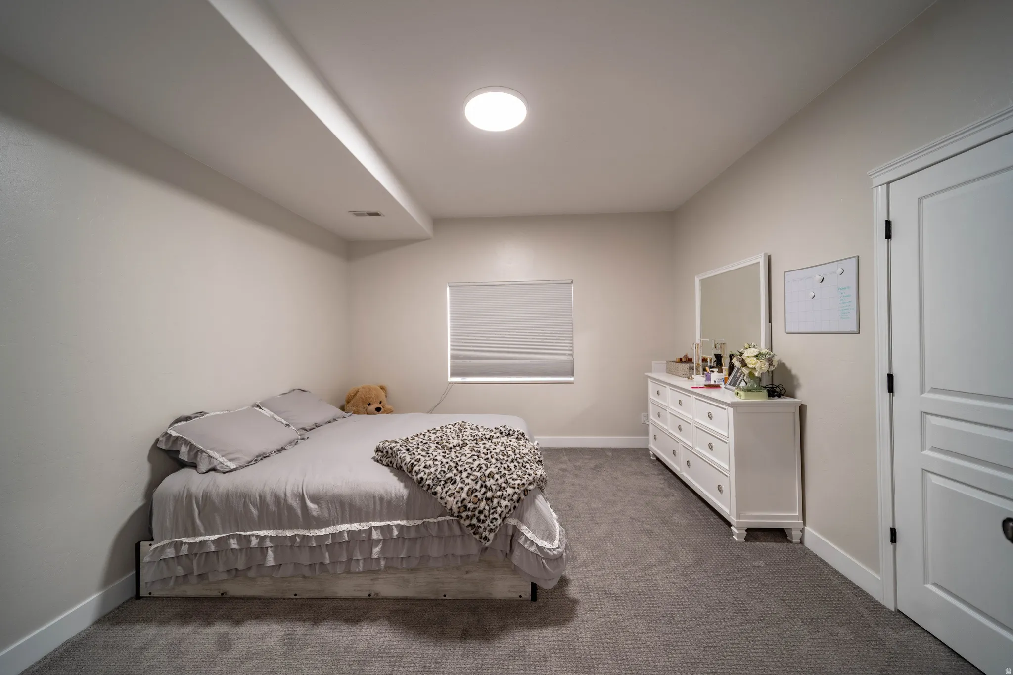 Bedroom featuring dark colored carpet and baseboards