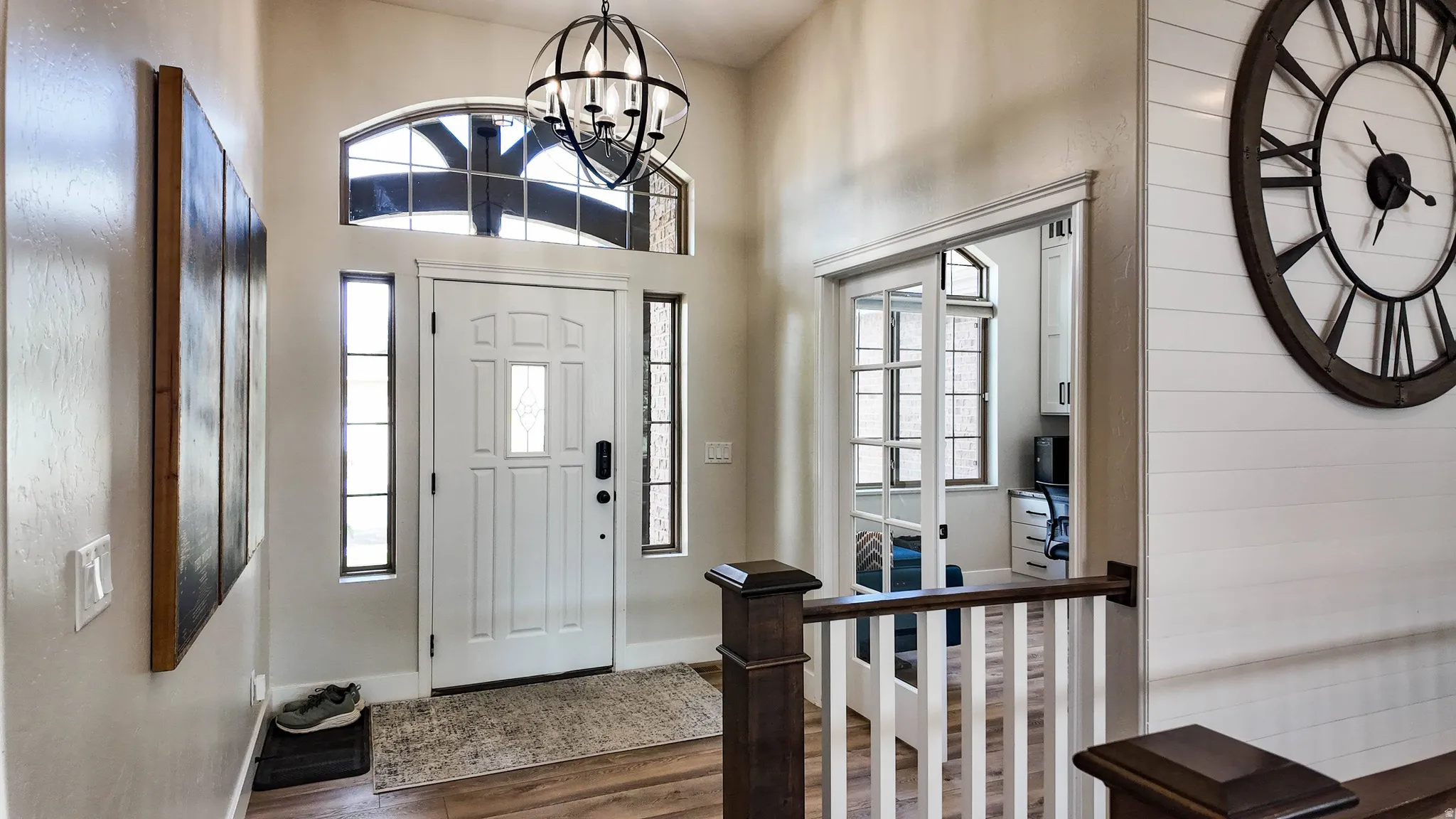 Foyer featuring dark wood finished floors, a high ceiling, and suspended lighting