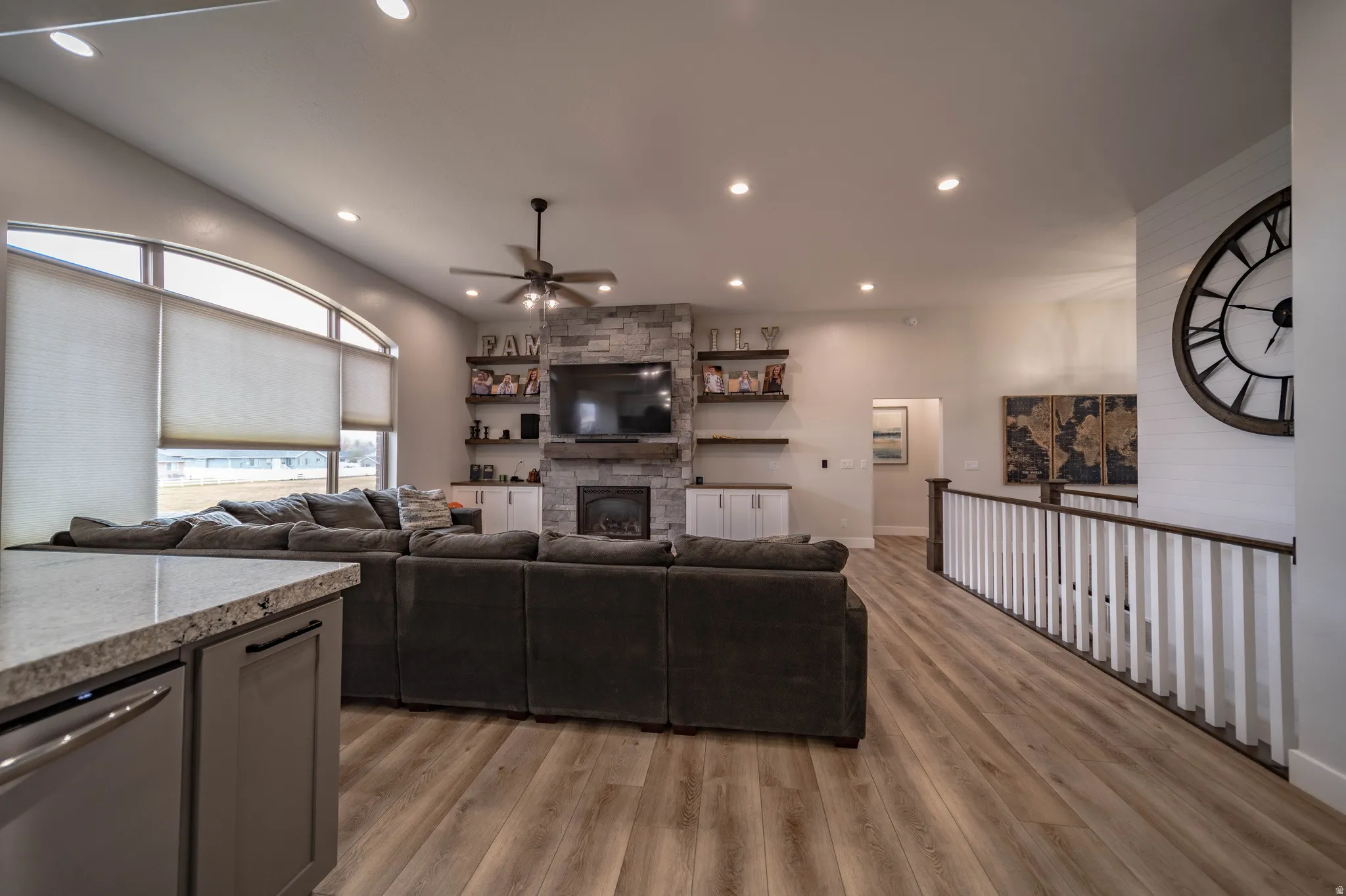 Living area with recessed lighting, light wood finished floors, a ceiling fan, and a fireplace