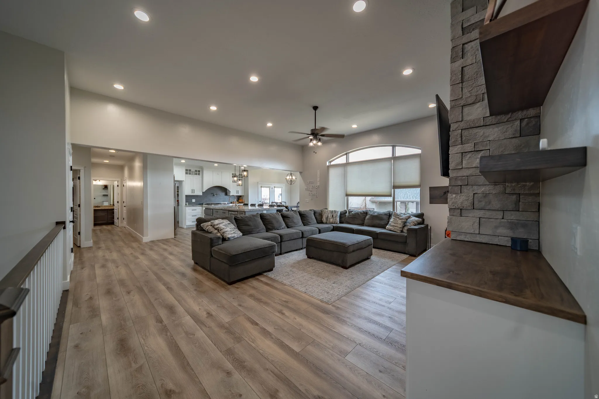 Living area with light wood-type flooring, ceiling fan, and recessed lighting