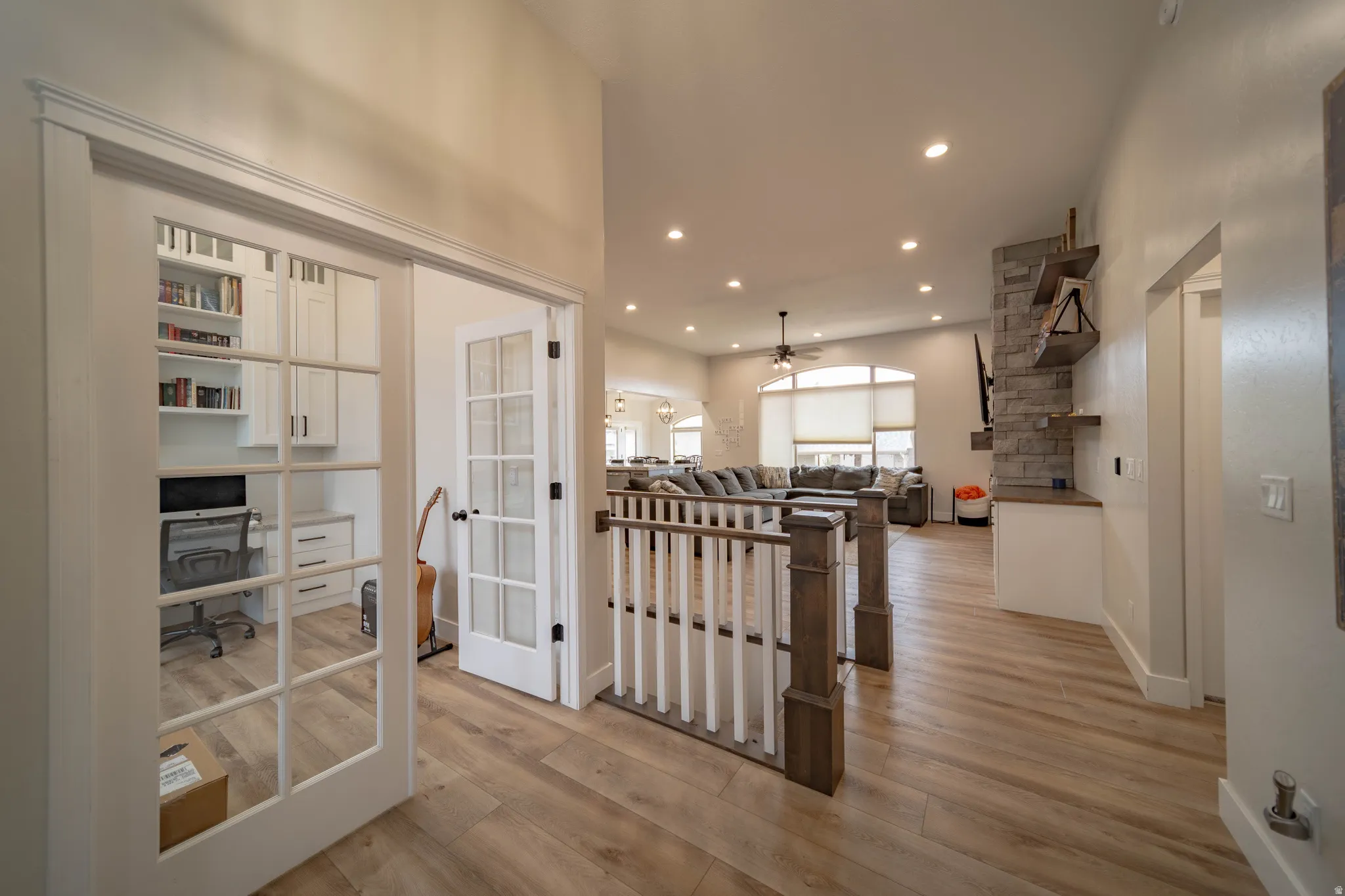 Hallway with light wood finished floors, recessed lighting, french doors, and an office area