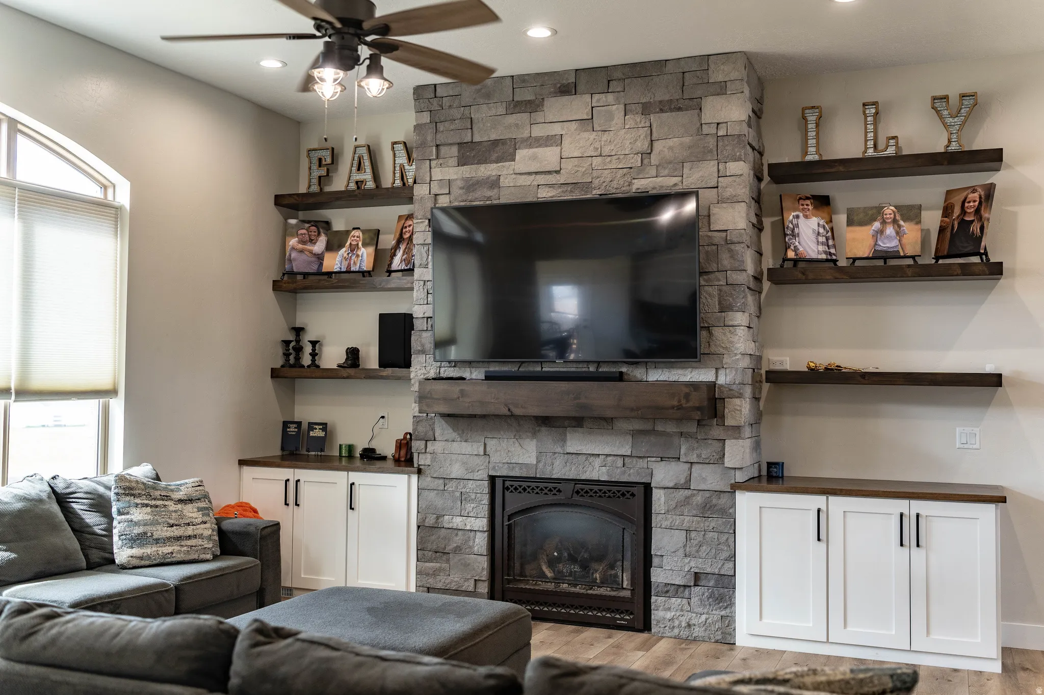 Living area featuring a ceiling fan, a fireplace, wood finished floors, plenty of natural light, and recessed lighting