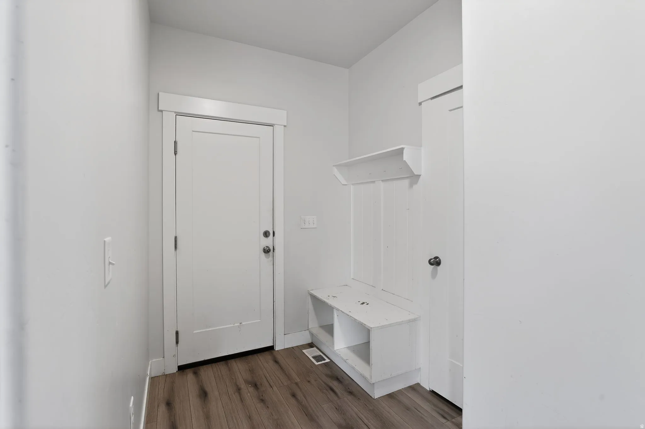 Mudroom with dark wood-style floors and baseboards