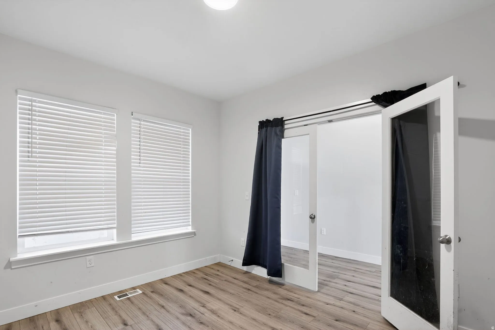 Unfurnished bedroom with light wood finished floors and baseboards