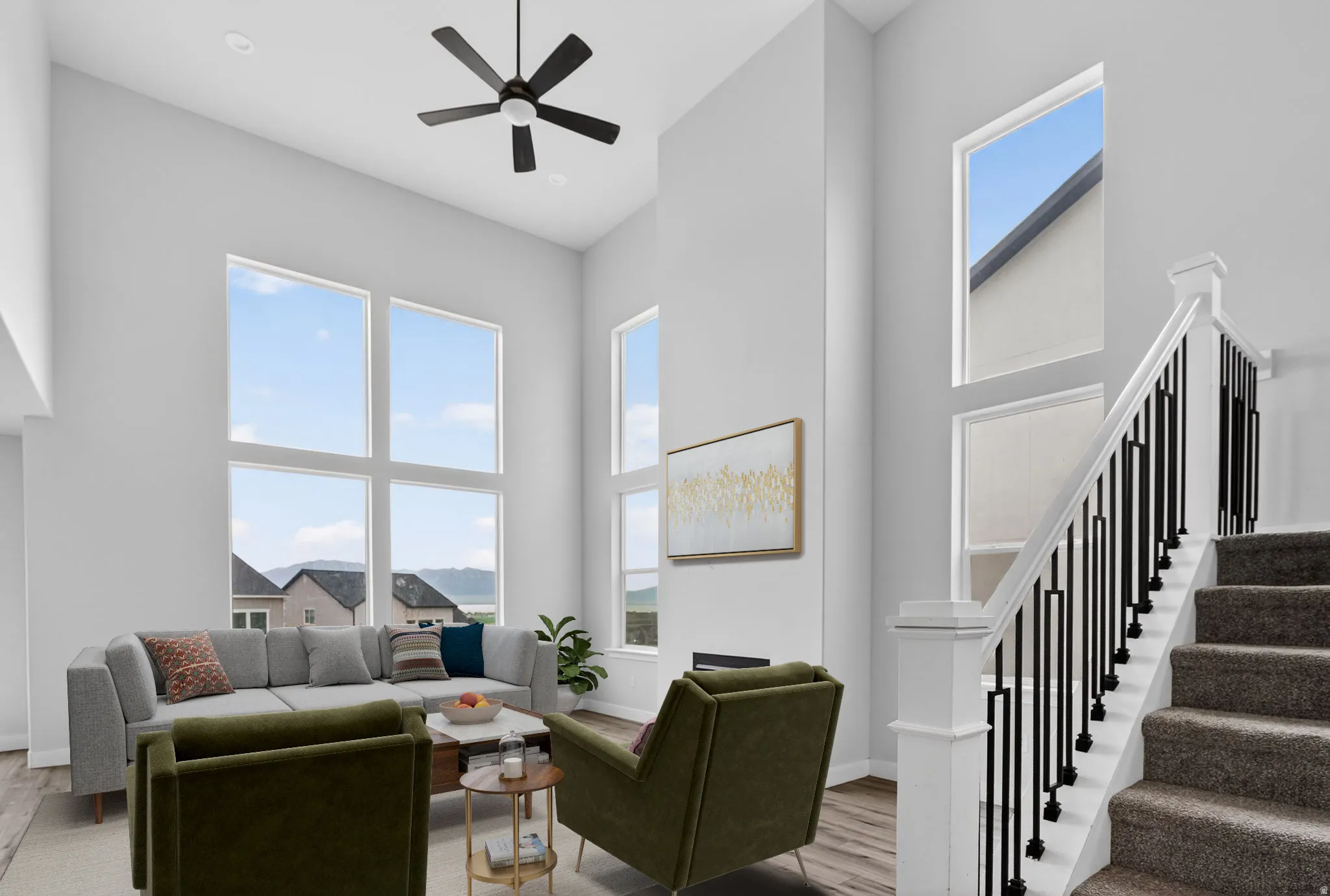 Living area with a high ceiling, light wood-style floors, and a ceiling fan