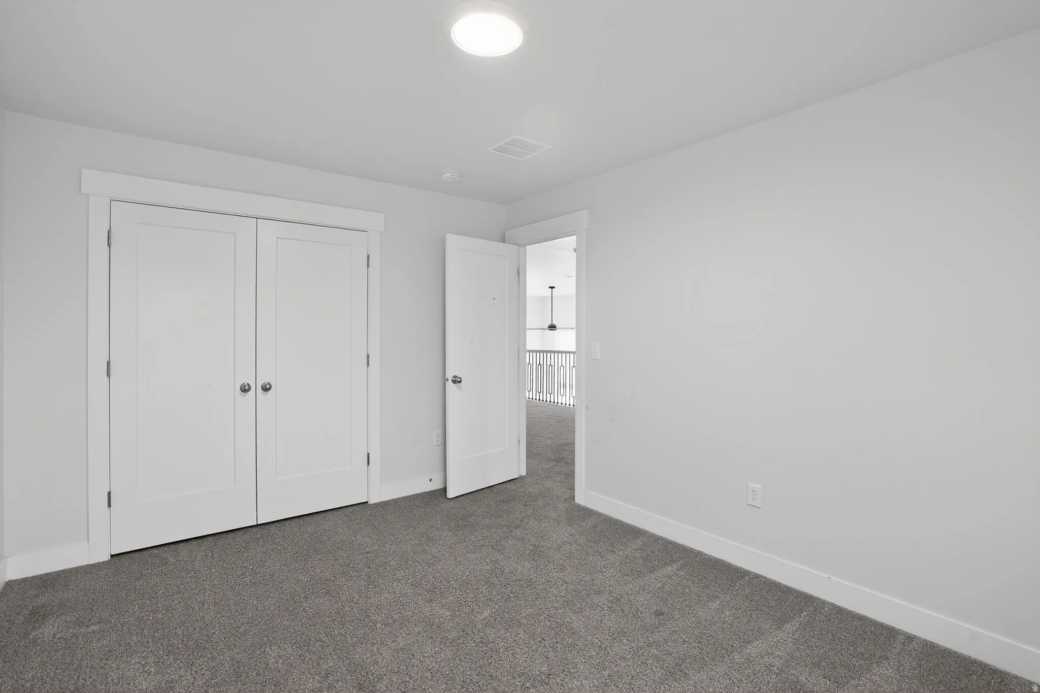 Unfurnished bedroom with dark carpet and a closet