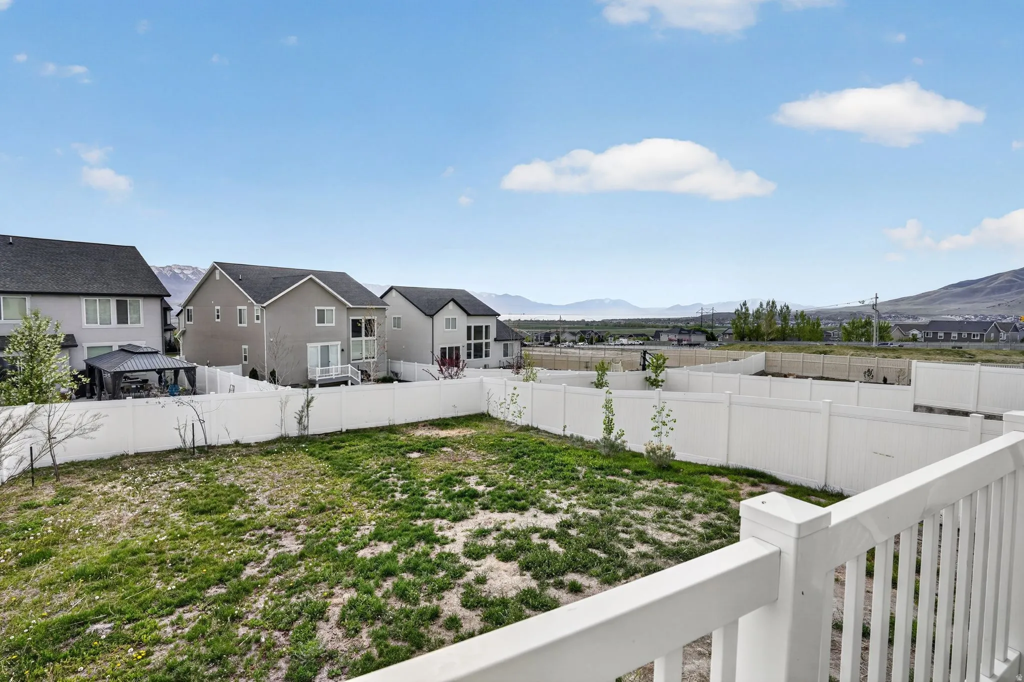 Fenced backyard with a mountain view, a residential view, and a balcony