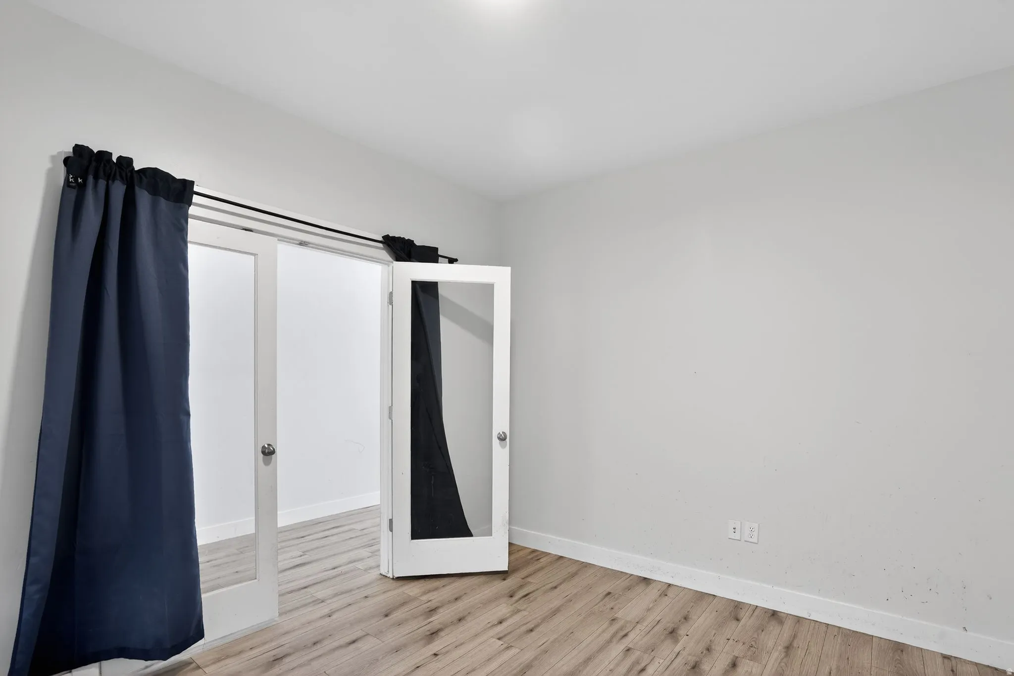 Unfurnished bedroom with light wood-style floors and baseboards