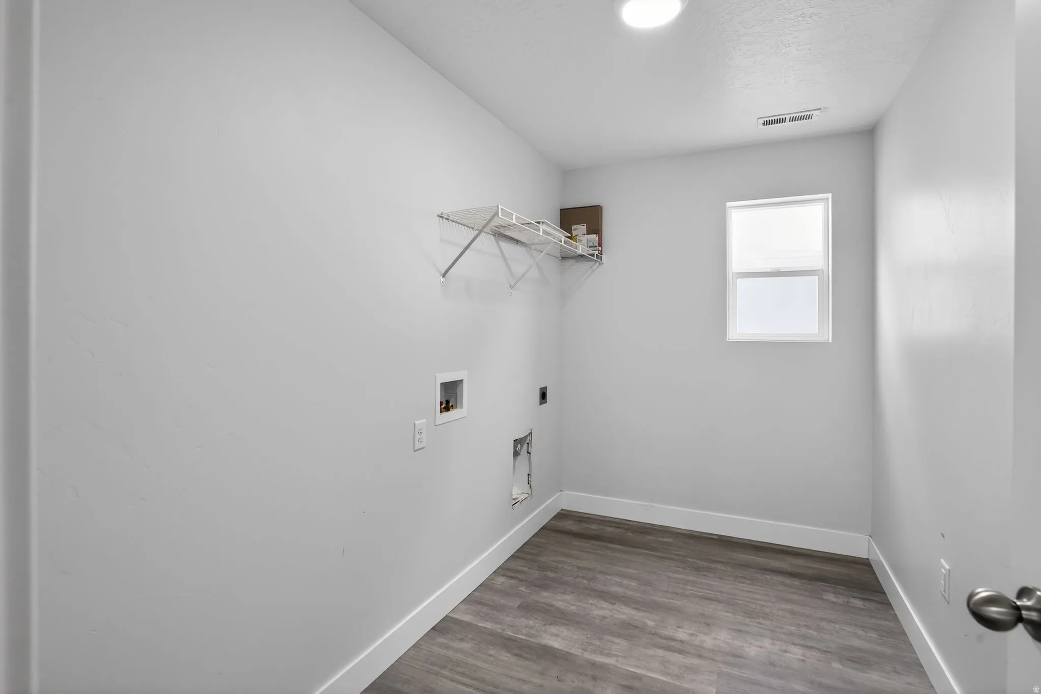 Laundry area featuring electric dryer hookup, dark wood-type flooring, and hookup for a washing machine
