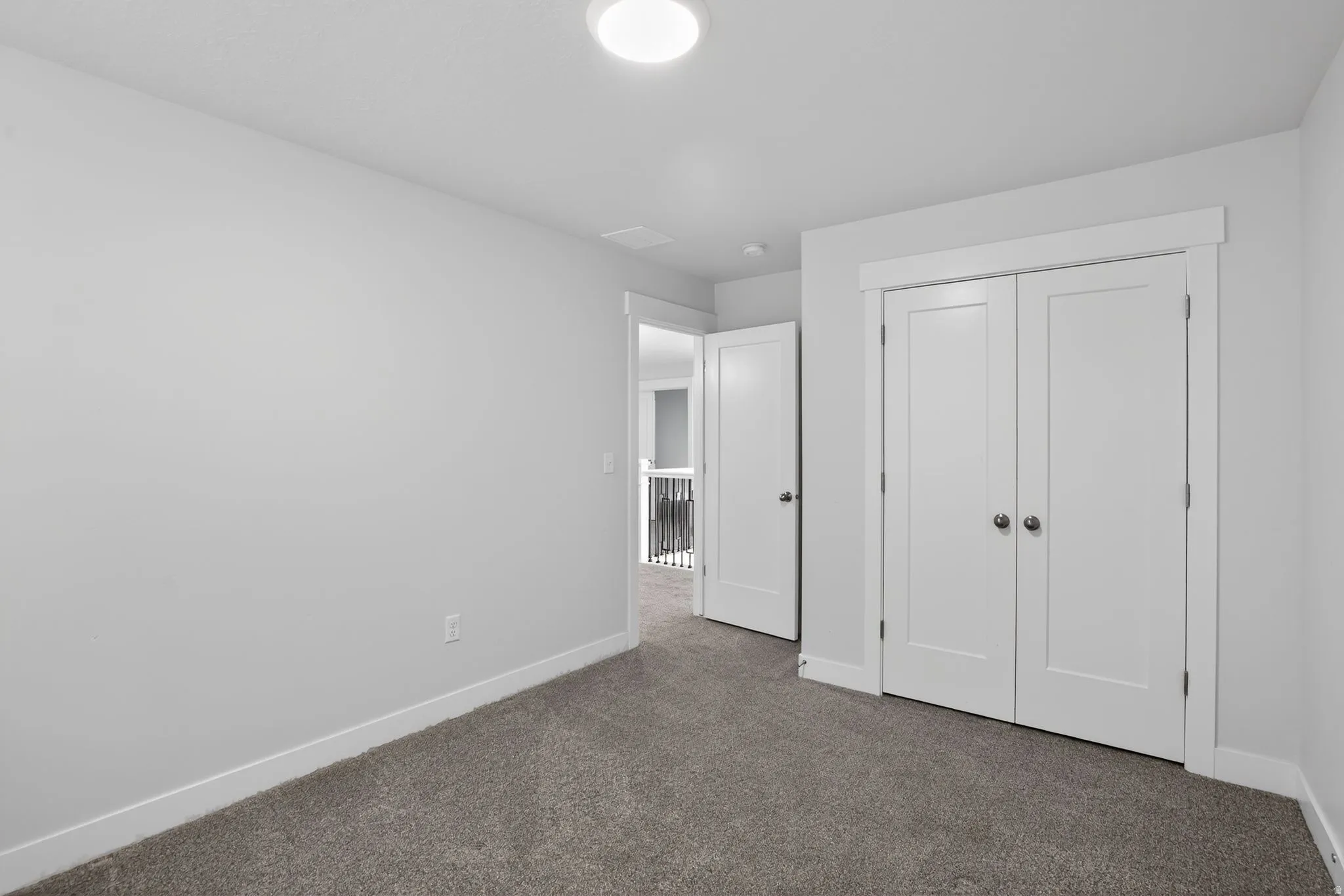 Unfurnished bedroom with dark carpet and a closet