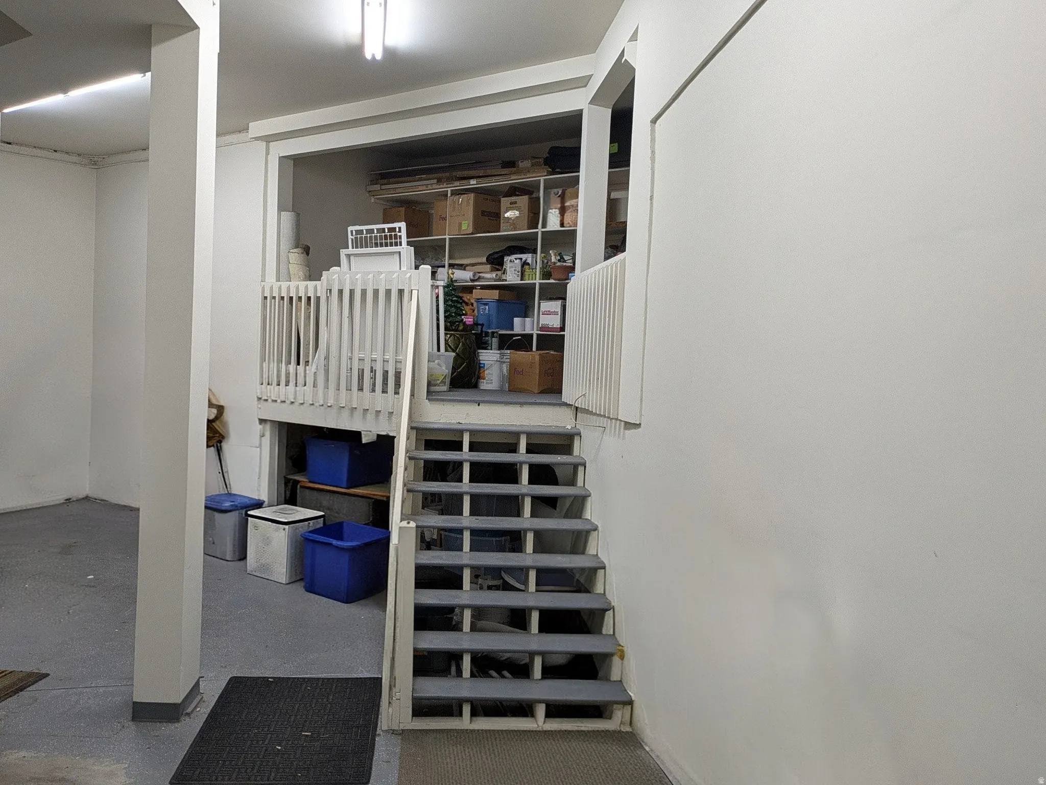 Garage storage area with white painted walls, and built-in shelving