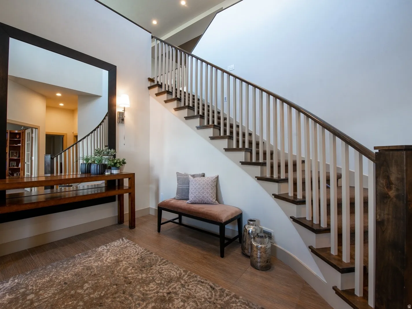 Stairs with wood finished floors, recessed lighting, and a high ceiling