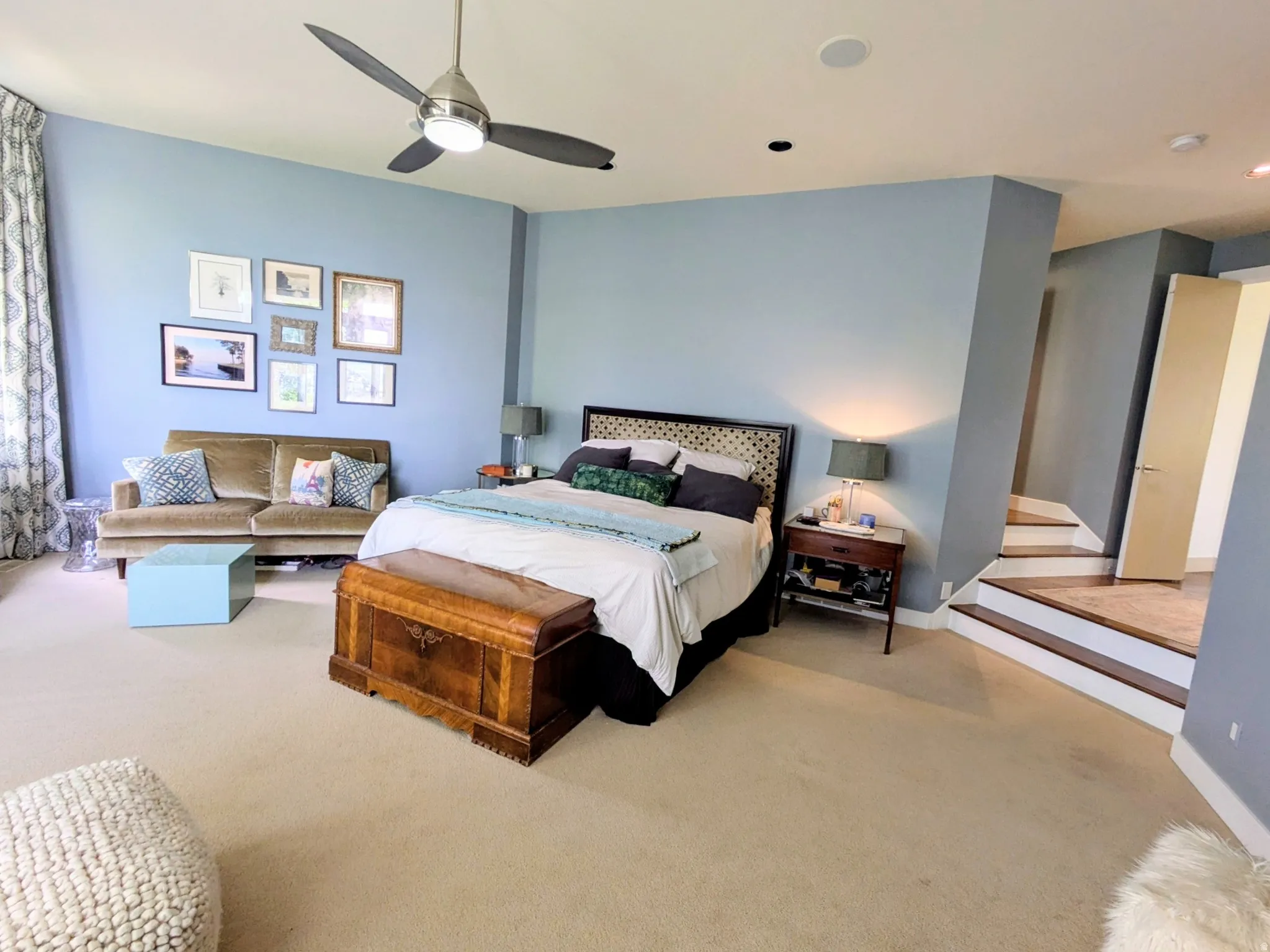 Carpeted Master bedroom featuring a contemporary ceiling fan with integrated lighting, recessed lighting, and a partial staircase with wood tread