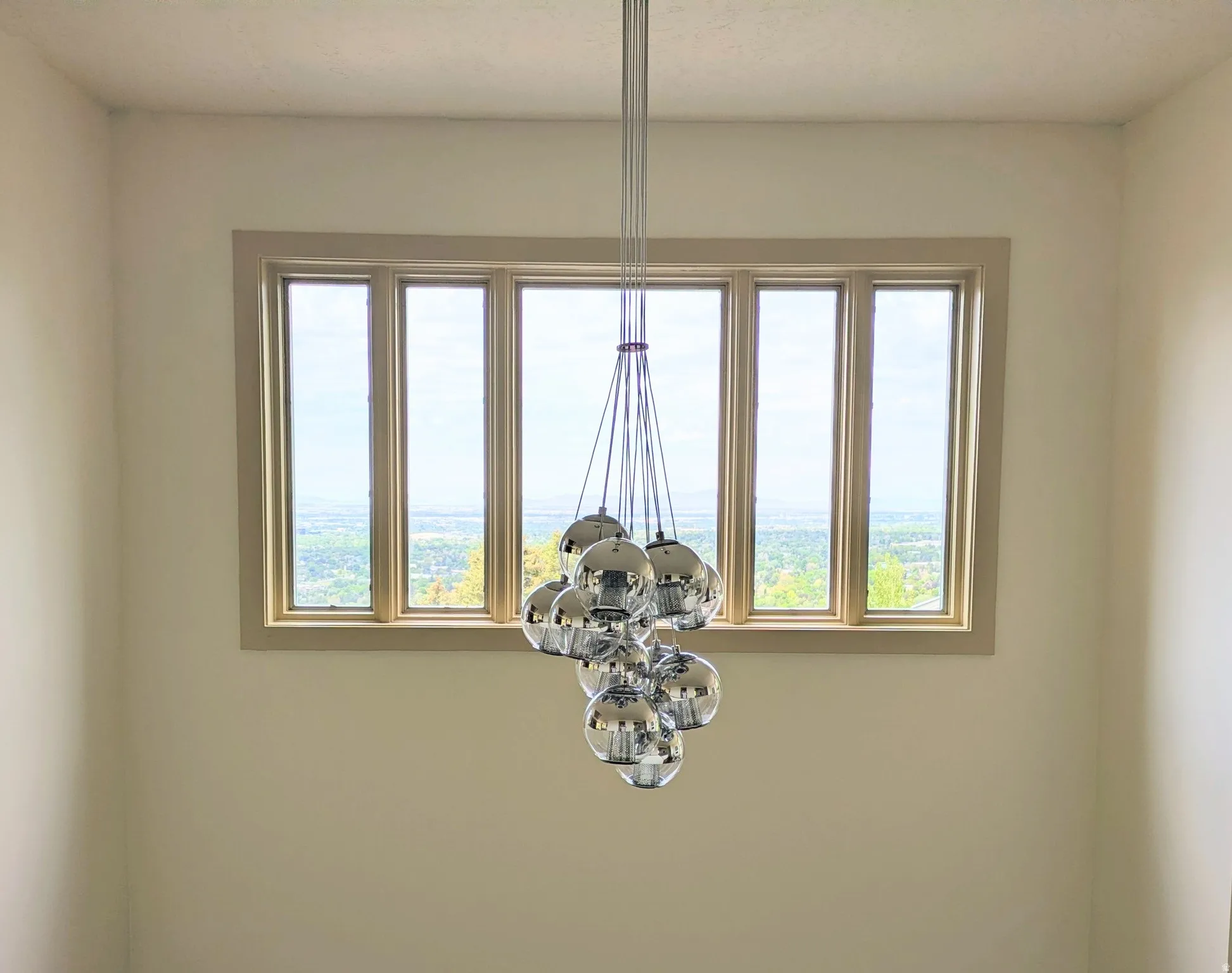 Expansive multi-pane window with wood-finish trim, offering a broad scenic backdrop