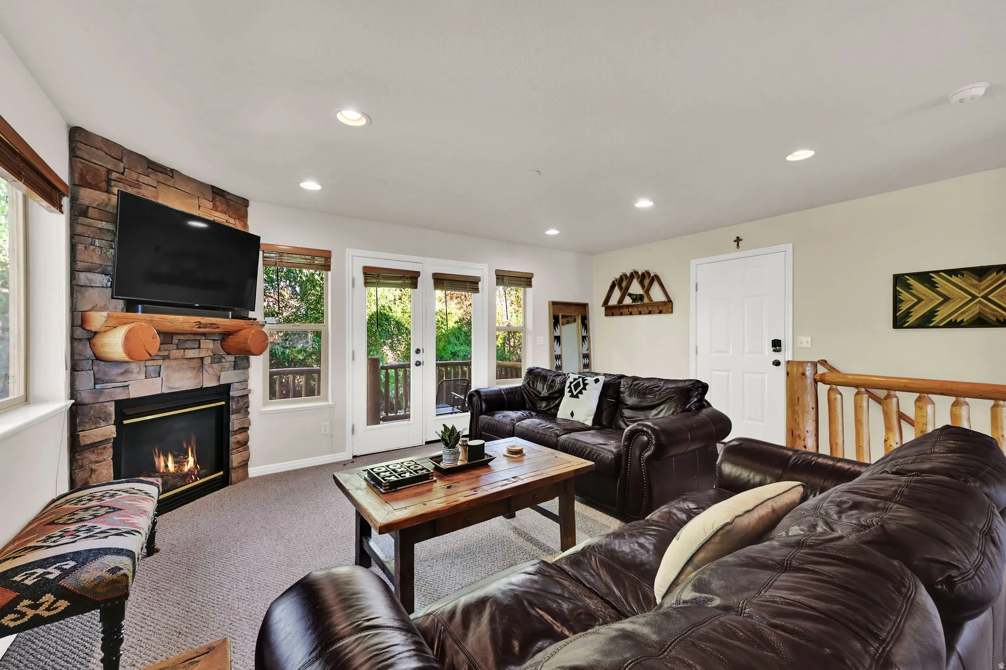 Carpeted living room featuring a fireplace, recessed lighting, and french doors