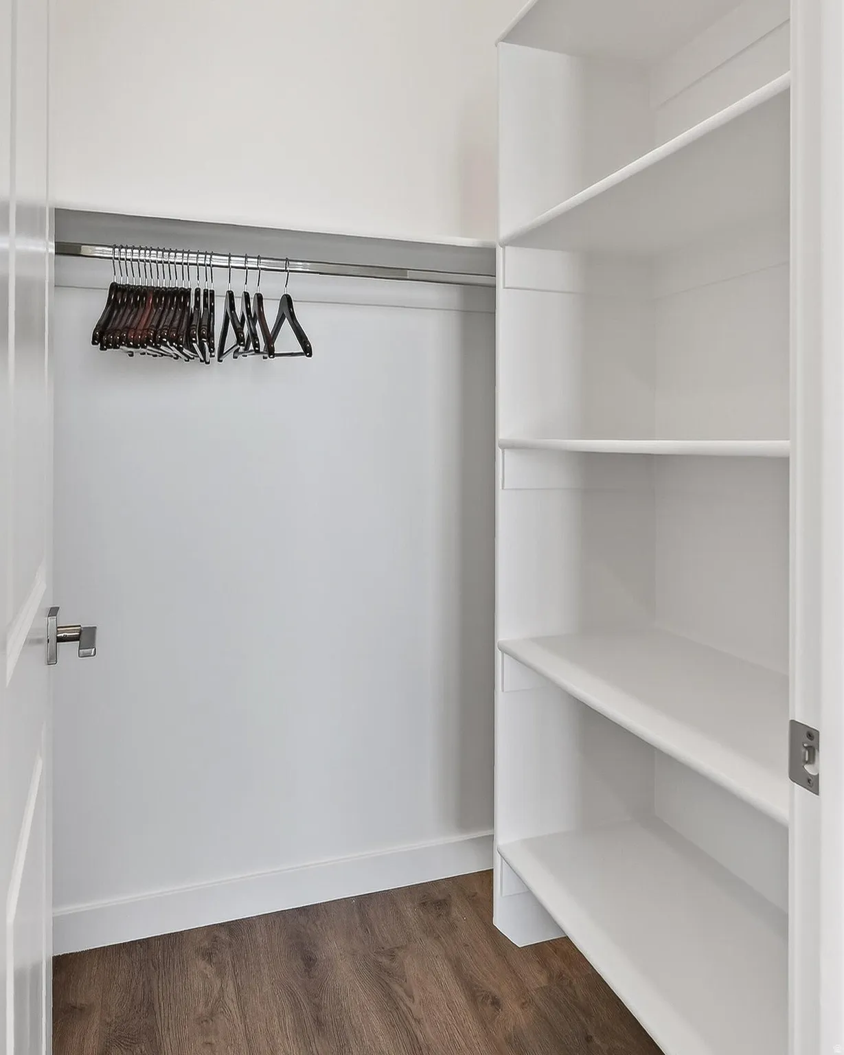 Walk in closet with dark wood-type flooring