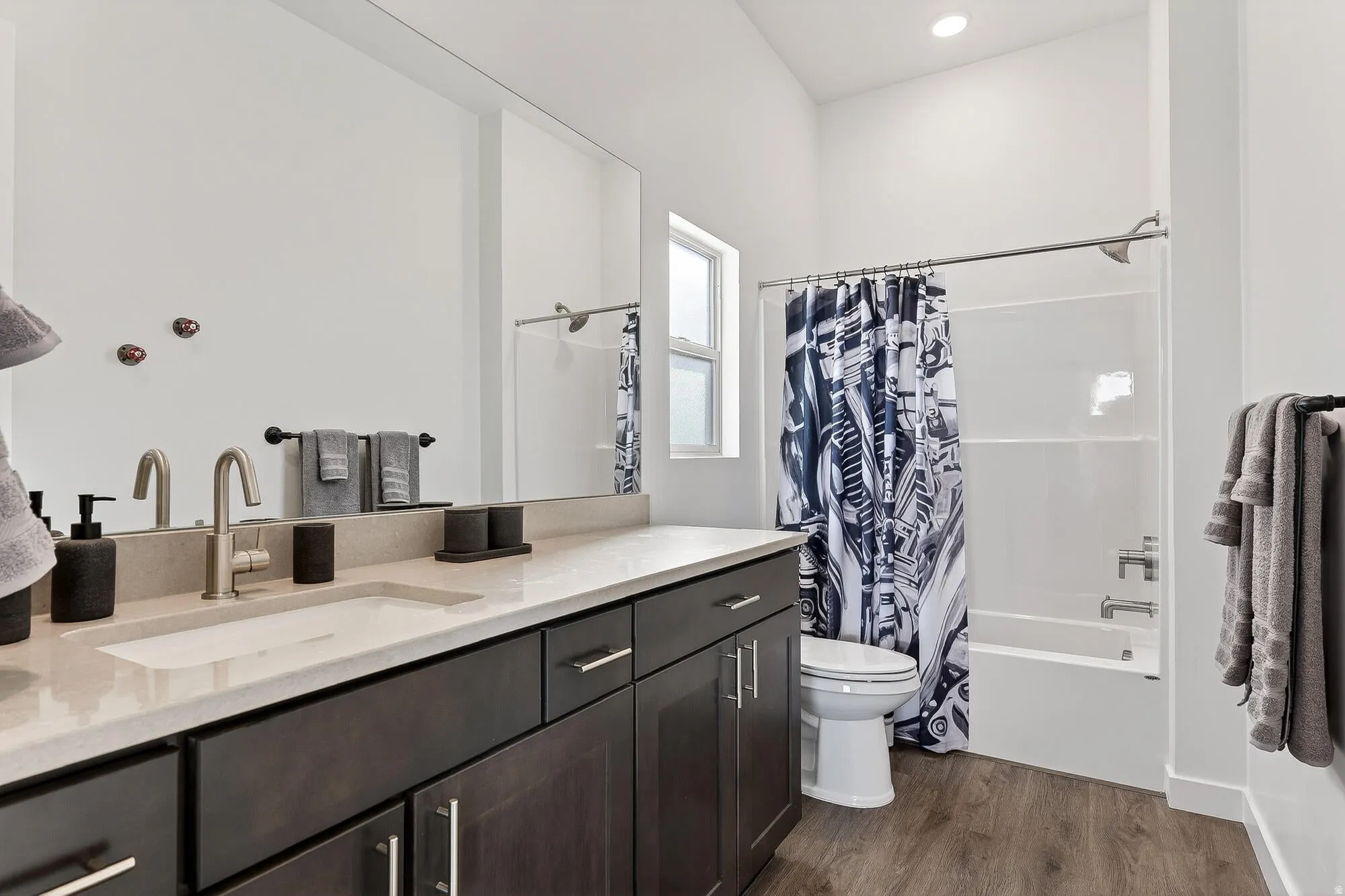 Full bathroom with vanity, dark wood-type flooring, shower / tub combo, and recessed lighting